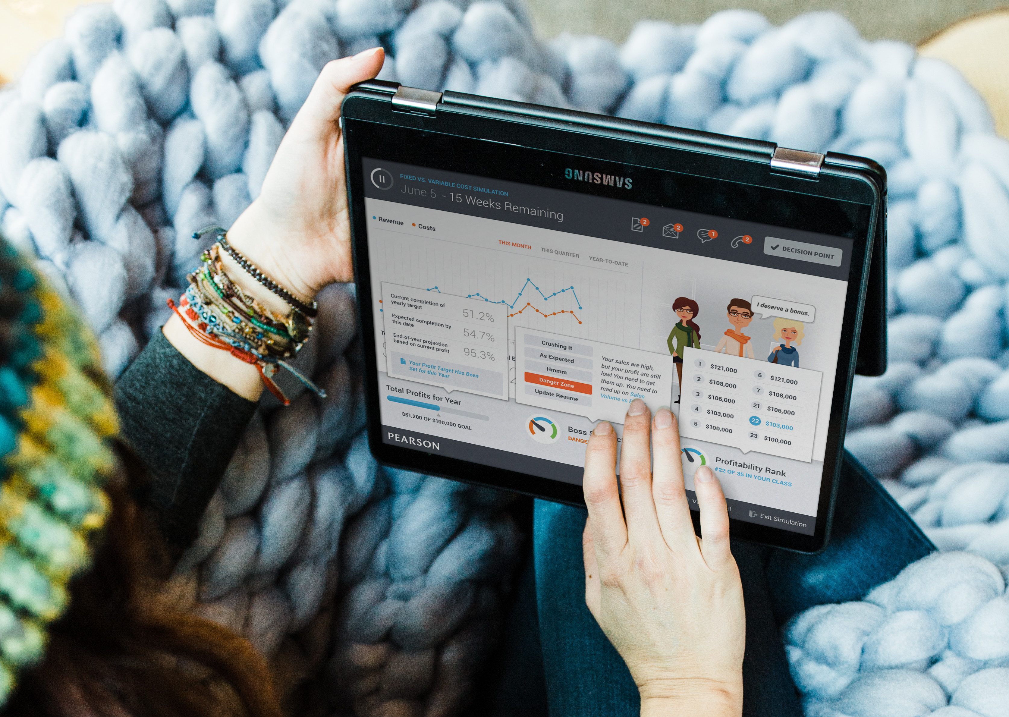 Close-up photo of hands interacting with a tablet displaying the Pearson Decision Simulator interface. The screens is displaying interactions for decision points in the app.